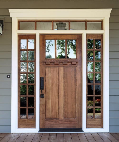 Modern fiberglass entry door with decorative glass sidelights and transom for style, durability, and energy efficiency.